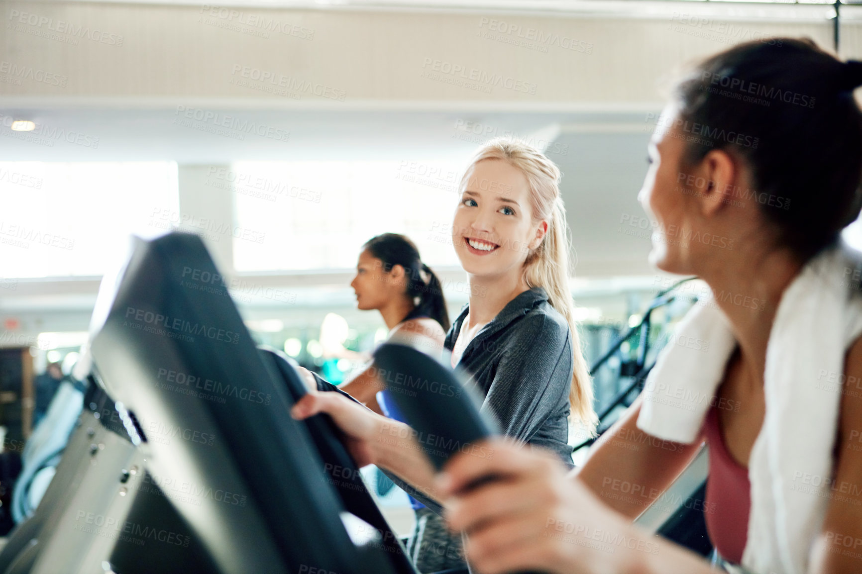 Buy stock photo Cropped shot of attractive young women working out on treadmills at the gym