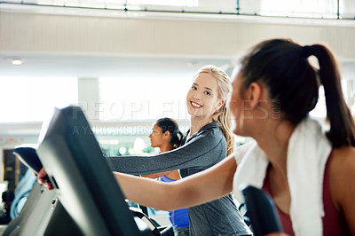 Buy stock photo Cropped shot of attractive young women working out on treadmills at the gym