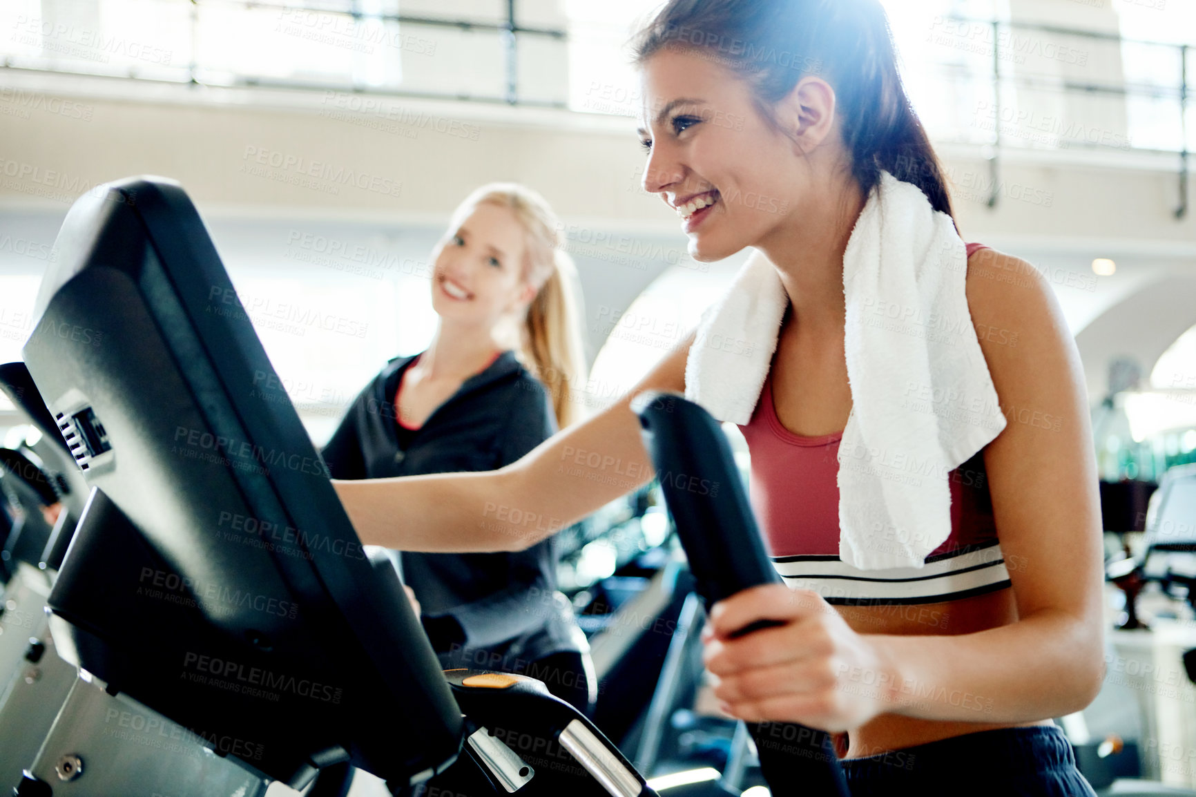 Buy stock photo Cropped shot of attractive young women working out on treadmills at the gym