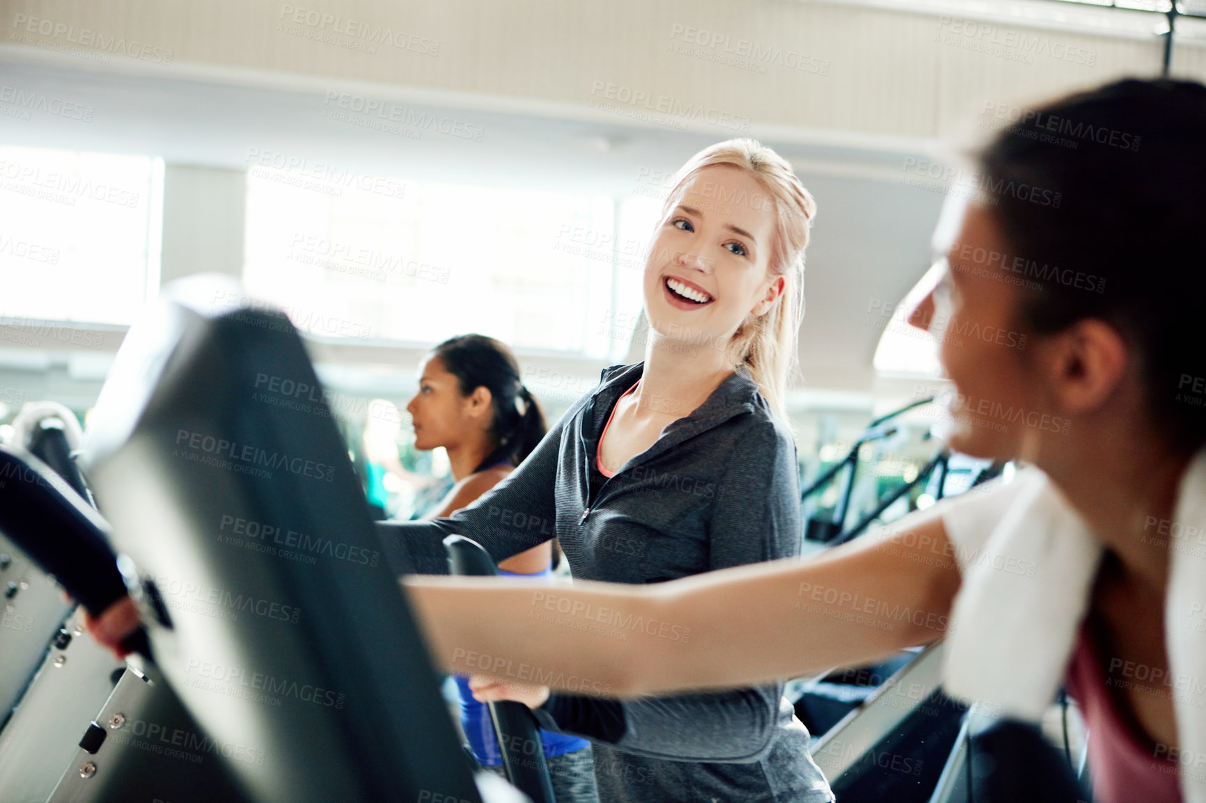 Buy stock photo Cropped shot of attractive young women working out on treadmills at the gym