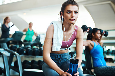 Buy stock photo Girl, gym and music listening with towel, break and serious for water bottle in training or fitness. Female person, drink and earphones for wellness, health with rest after exercise or workout
