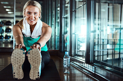 Buy stock photo Shot of an attractive young woman going through her warmup routine in the gym