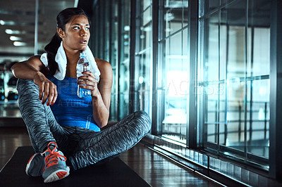 Buy stock photo Shot of an attractive young woman taking a break during her workout in the gym