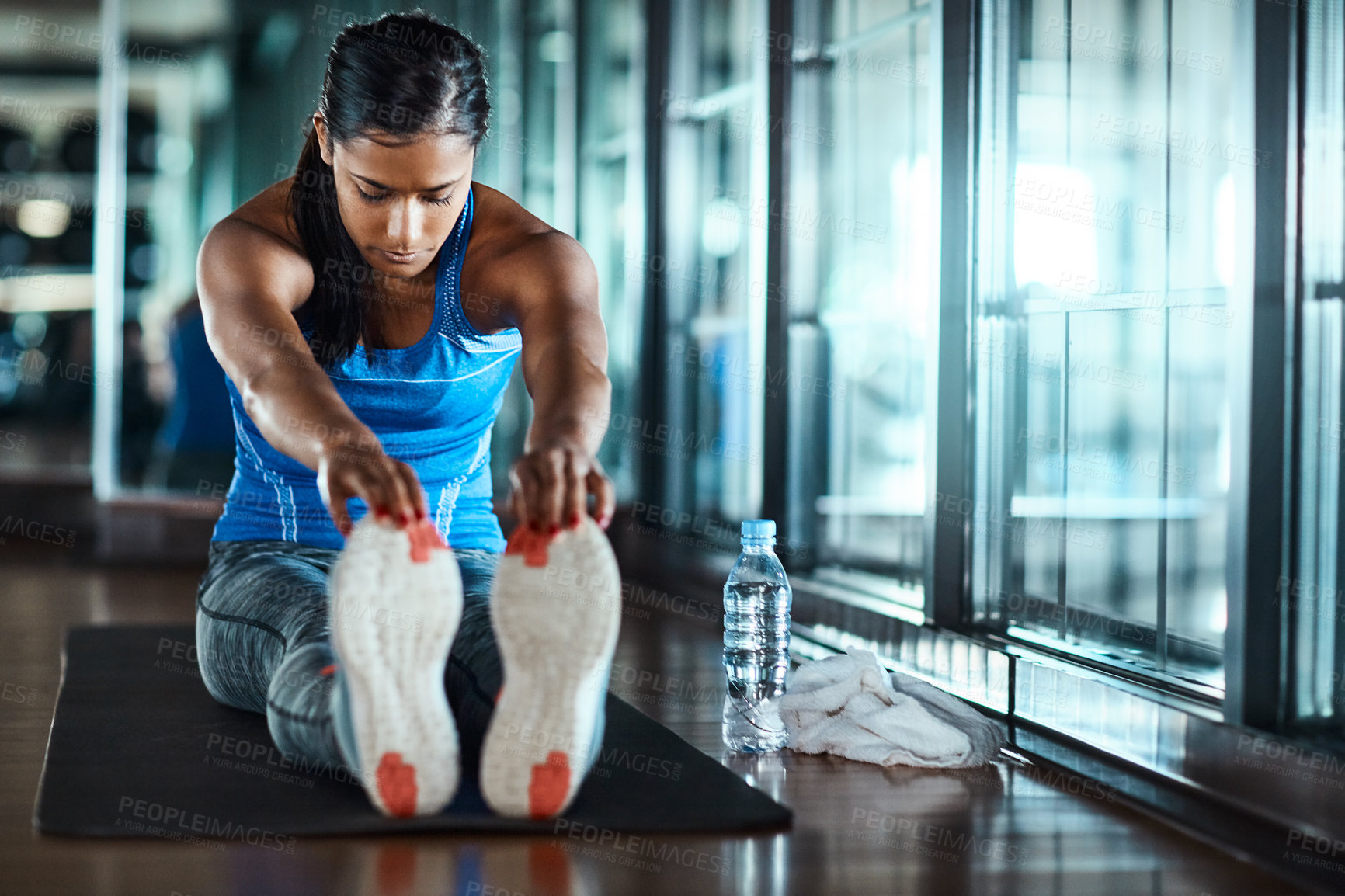 Buy stock photo Exercise, woman and stretching legs at gym to start workout, fitness routine and getting ready. Health club, girl and warm up on mat for training preparation, muscle coordination and enhance posture