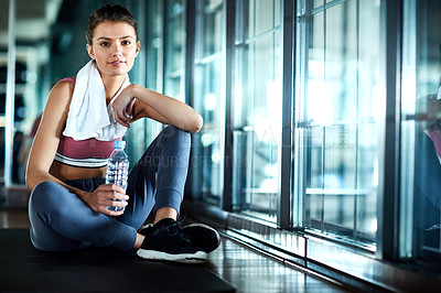 Buy stock photo Shot of an attractive young woman taking a break during her workout in the gym