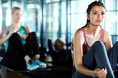 Buy stock photo Shot of an attractive young woman taking a break during her workout in the gym