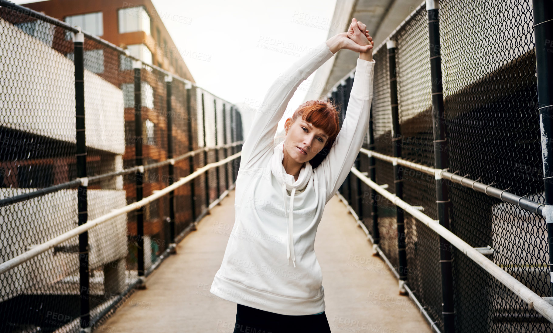 Buy stock photo Cropped portrait of an attractive young woman stretching before her run in the city