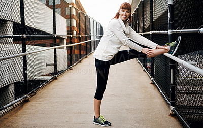 Buy stock photo Full length shot of an attractive young woman stretching before her run in the city