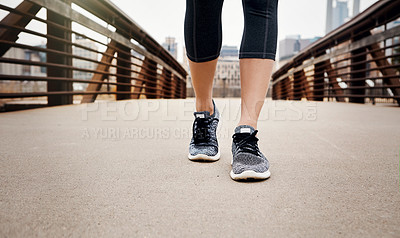 Buy stock photo Cropped shot of an unrecognizable young woman taking a run through the city