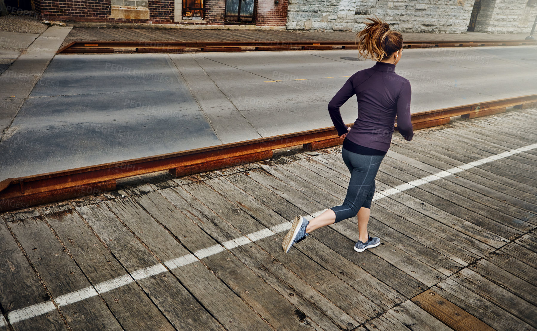 Buy stock photo Rearview shot of an unrecognizable young woman running through the city