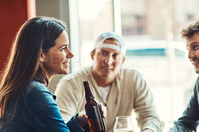 Buy stock photo Shot of a happy young woman enjoying the company in a bar