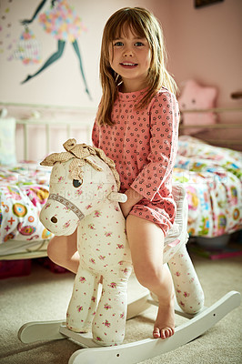 Buy stock photo Portrait, child and playful with rocking horse in bedroom, family home or house as little girl for fun in UK. Kid, adventure and happiness with confidence, smile or excited on weekend for development