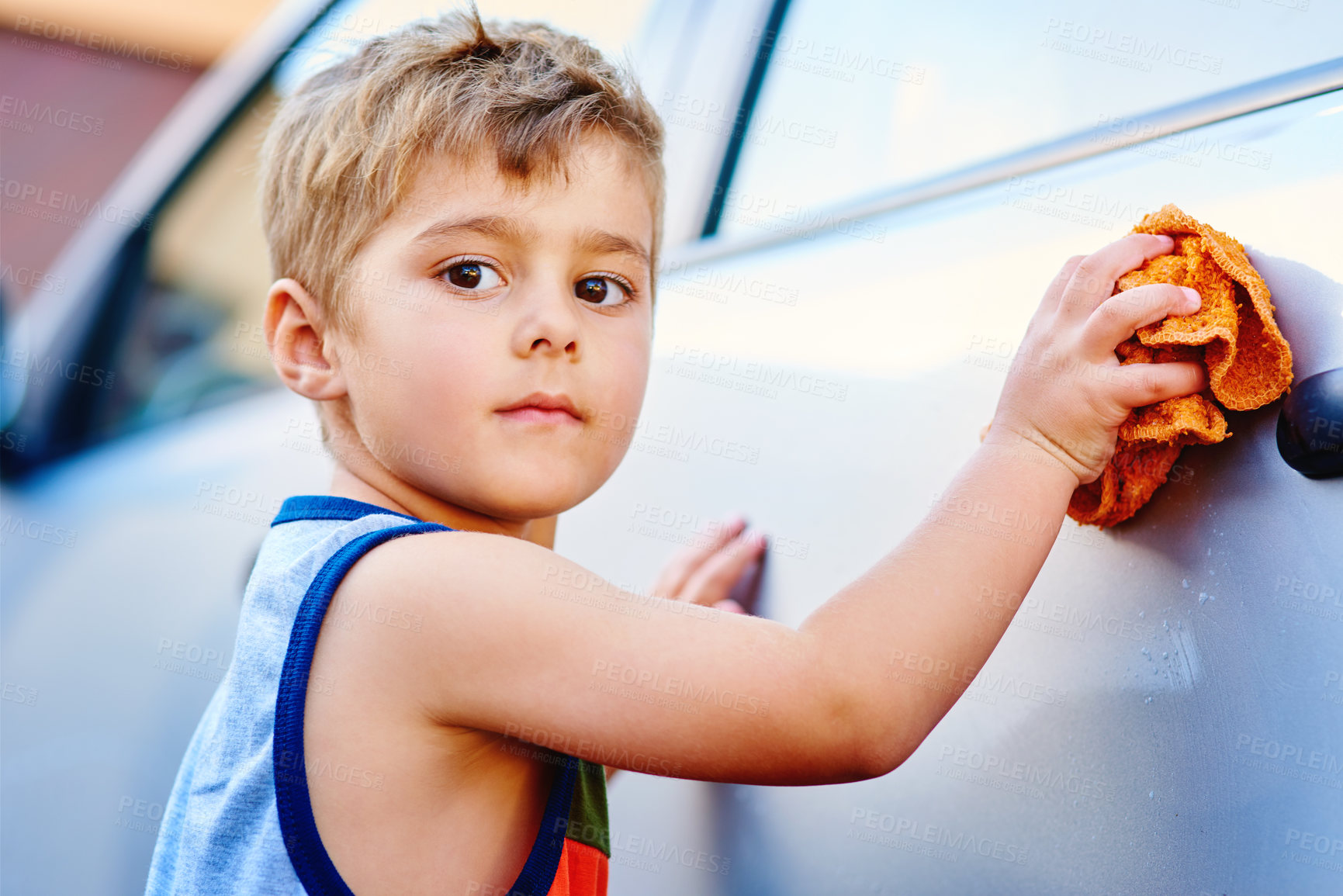 Buy stock photo Portrait, child and wash car in driveway for chores or outdoor activity, cloth and serious for cleaning vehicle, Boy, helping and scrubbing automobile for housework, learning and responsibility.