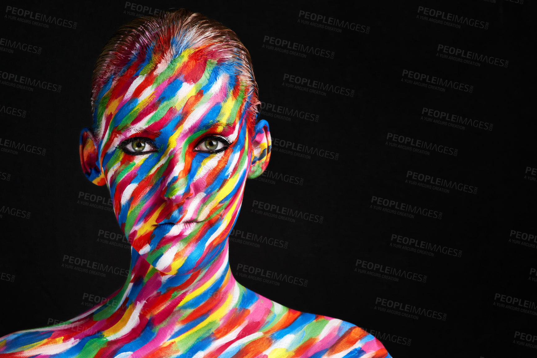Buy stock photo Studio shot of a young woman posing with brightly colored paint on her face against a black background