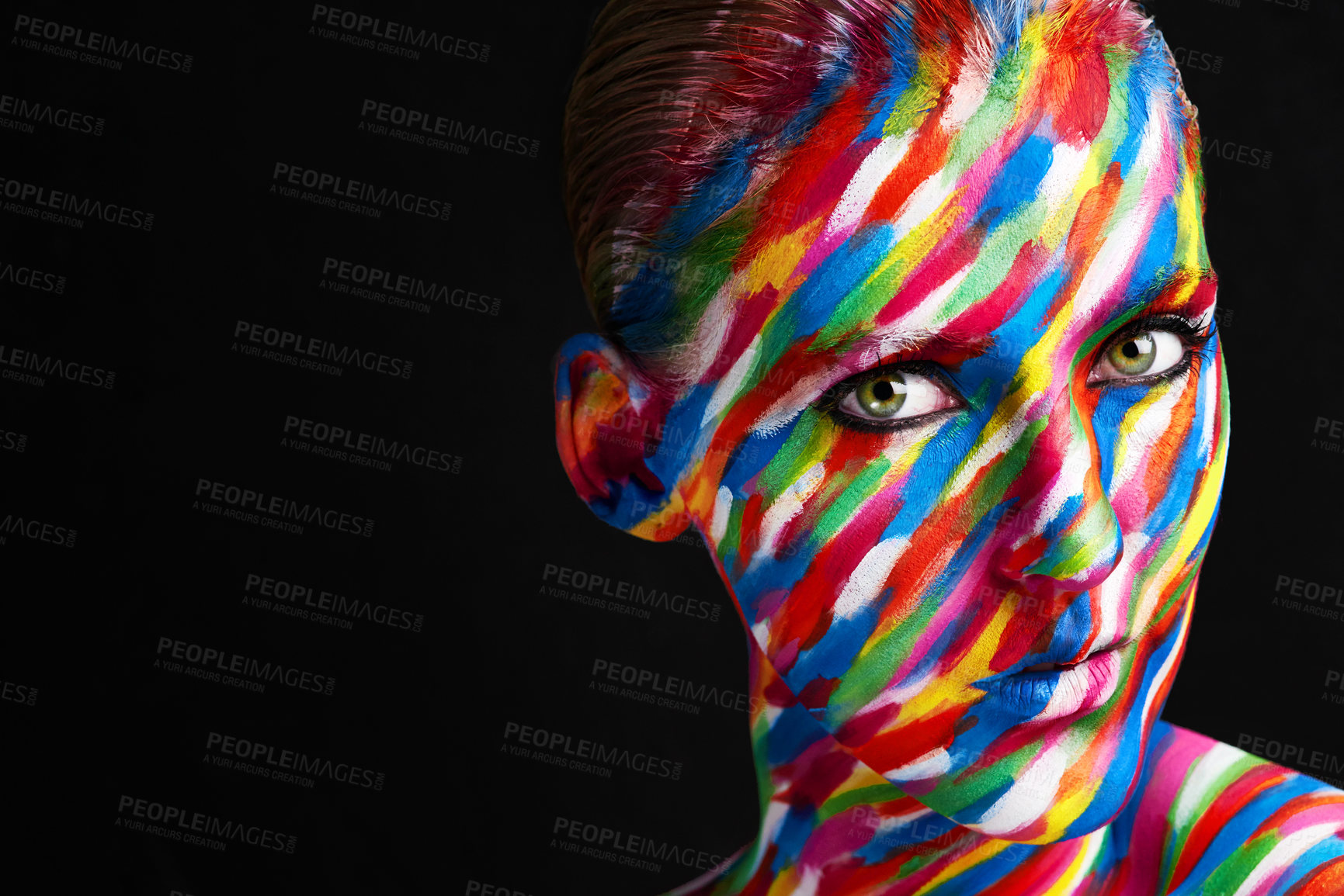 Buy stock photo Studio shot of a young woman posing with brightly colored paint on her face against a black background