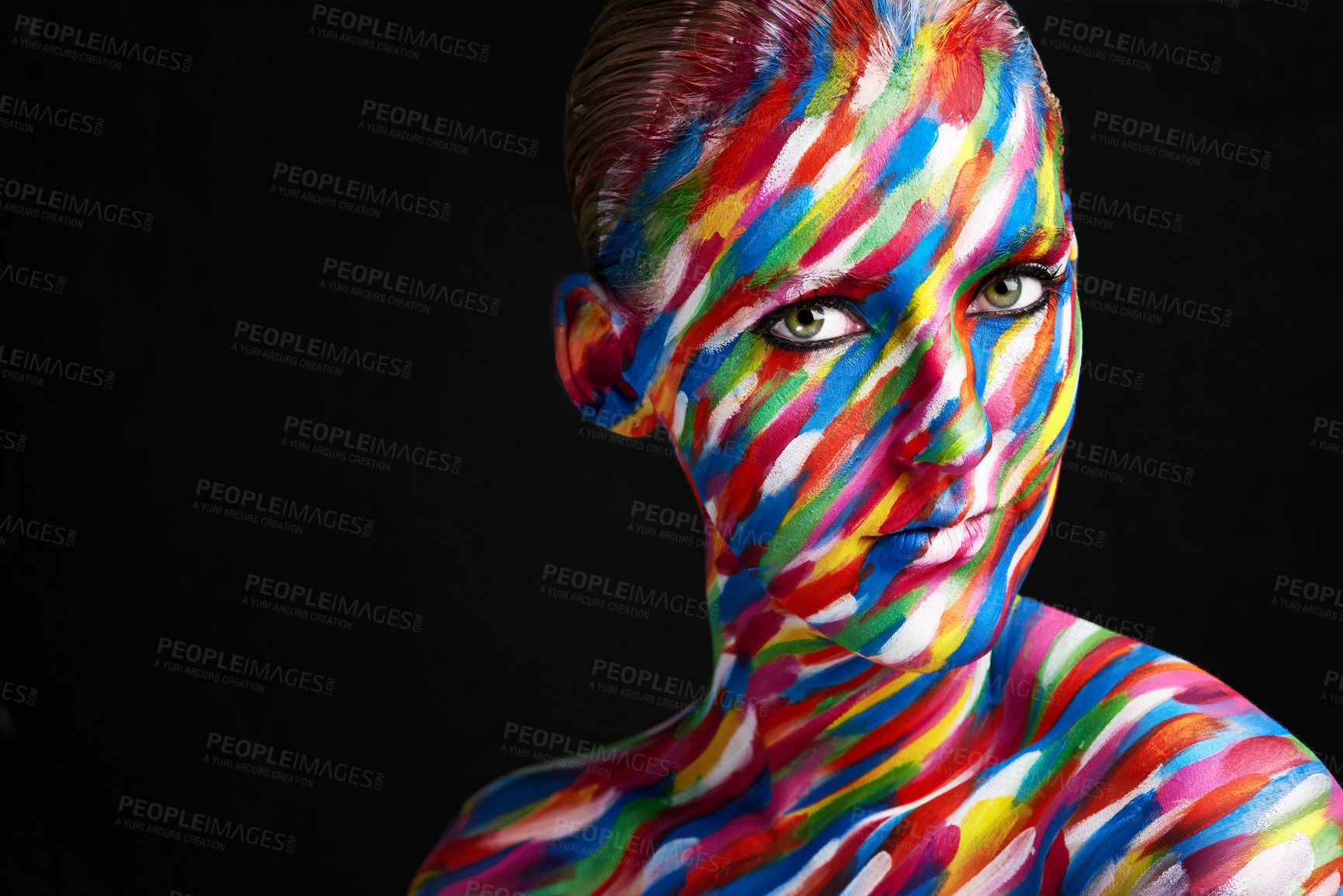 Buy stock photo Studio shot of a young woman posing with brightly colored paint on her face against a black background