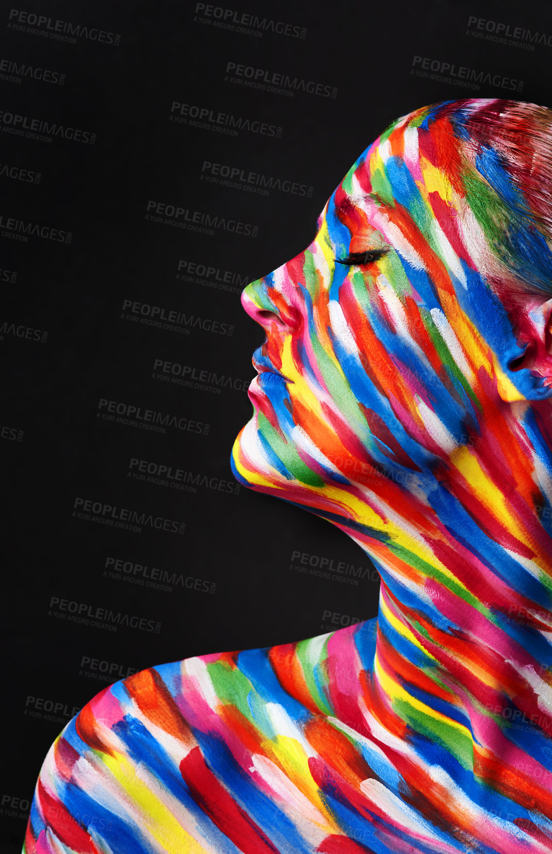 Buy stock photo Studio shot of a young woman posing with brightly colored paint on her face against a black background