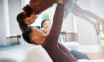 Buy stock photo Cropped shot of a handsome young man playing with his daughter on the sofa at home