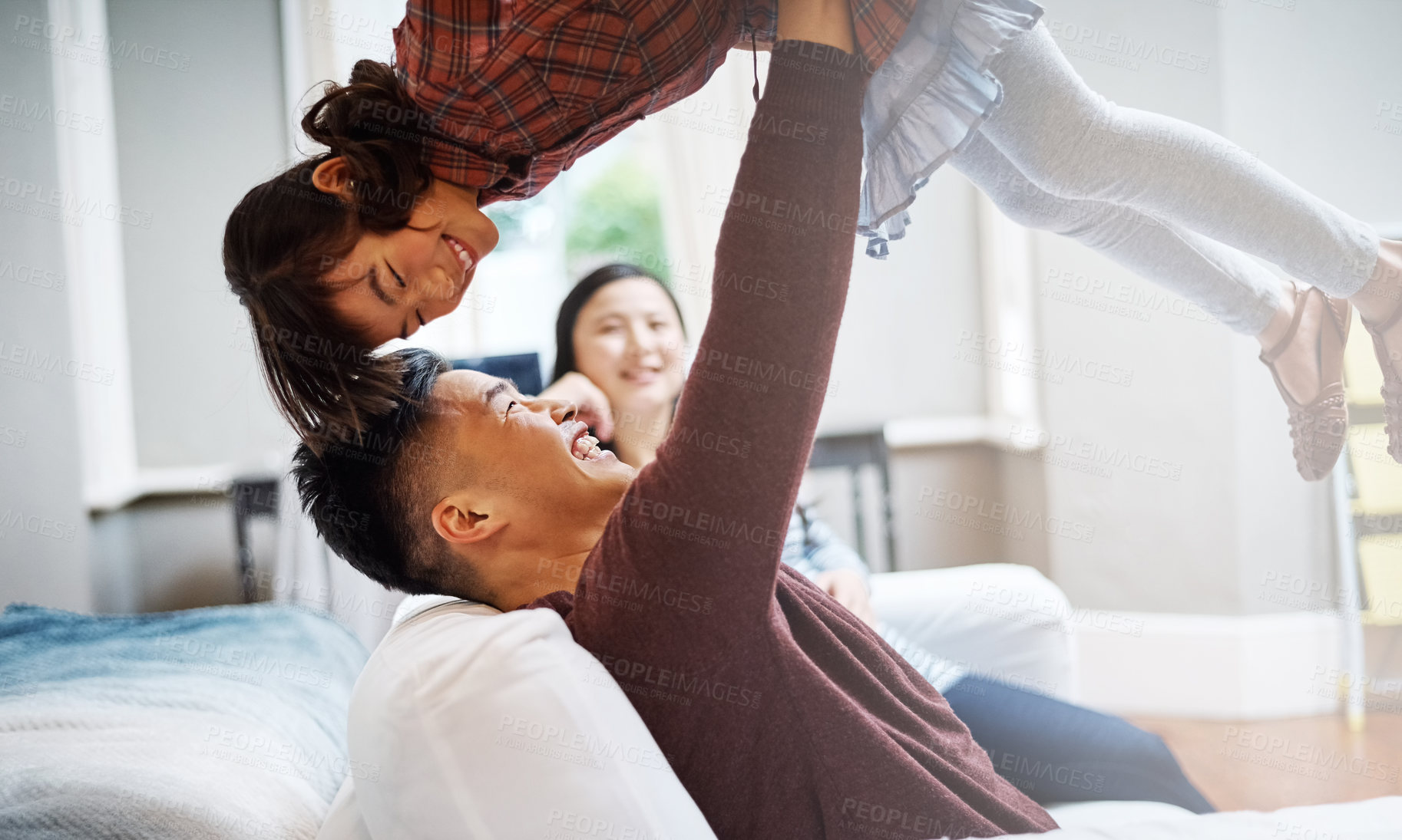 Buy stock photo Cropped shot of a handsome young man playing with his daughter on the sofa at home