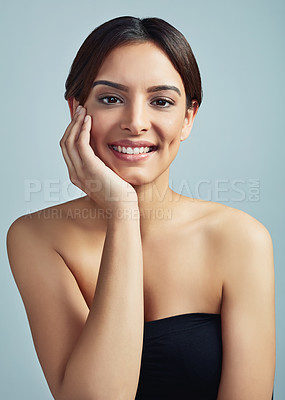 Buy stock photo Studio portrait of a beautiful young woman with flawless skin against a grey background