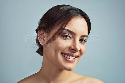 Buy stock photo Studio portrait of a beautiful young woman with flawless skin against a grey background