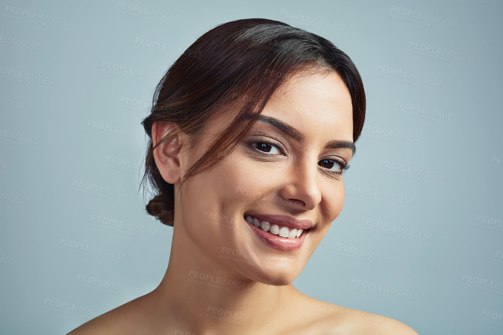 Buy stock photo Studio portrait of a beautiful young woman with flawless skin against a grey background