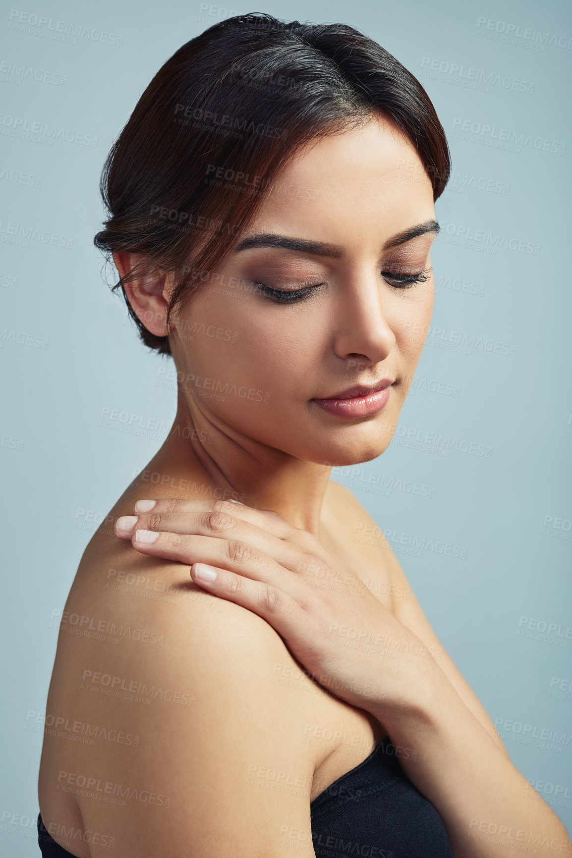 Buy stock photo Woman, feeling shoulder and skincare in studio, confident beauty and cosmetics on blue background. Female person, touch and results of body treatment, aesthetic and healthy dermatology wellness