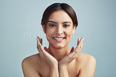 Buy stock photo Studio portrait of a beautiful young woman with flawless skin against a grey background