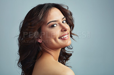 Buy stock photo Studio portrait of a beautiful young woman with flawless skin against a grey background