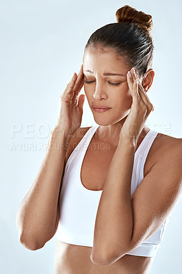 Buy stock photo Frustrated woman, headache and stress with pain in anxiety, depression or burnout on a gray studio background. Tired or exhausted female person or athlete with migraine or mental health after workout