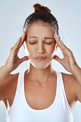 Buy stock photo Tired woman, headache and stress with pain in anxiety, depression or burnout on a gray studio background. Frustrated or exhausted female person or athlete with migraine or mental health after workout