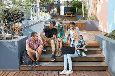 Buy stock photo Shot of a group of young students enjoying a break outdoors on campus
