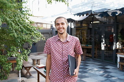 Buy stock photo Shot of a young male student enjoying a break outdoors on campus