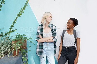 Buy stock photo Women students, diversity and wall at university for talking together with friendship, scholarship and education. Global girls, chat and background at campus for learning with smile, study and class