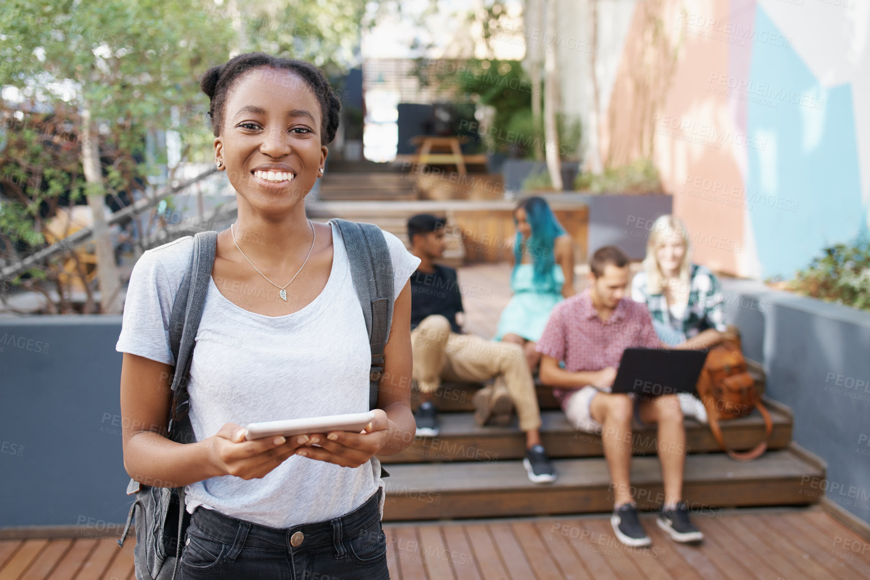 Buy stock photo Shot of a group of young students enjoying a break outdoors on campus