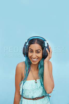 Buy stock photo Headphones, smile and portrait of girl in studio with audio for music streaming, online radio or podcast. Indian student, happy and person with tech for media, sound and connection on blue background