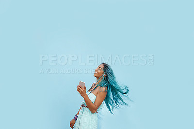 Buy stock photo Girl, earphones and phone for song in studio, website and online for streaming playlist on blue background. Female person, mockup space and dancing with energy, kpop and app for music in profile
