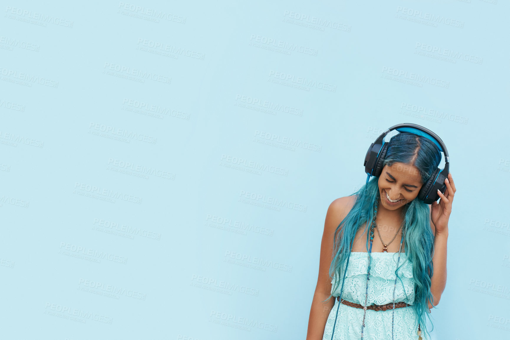 Buy stock photo Woman, headphones and laugh with music, mockup space and blue wall background on campus. Student, positivity and podcast audio or radio for education, college and confidence for university break