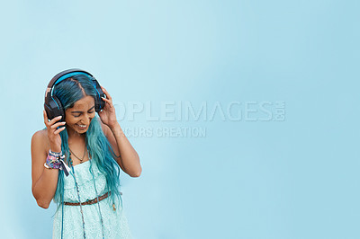 Buy stock photo Woman, headphones and listen with music, mockup space and blue wall background on campus. Student, satisfaction and podcast audio or radio for education, college and confidence for university break
