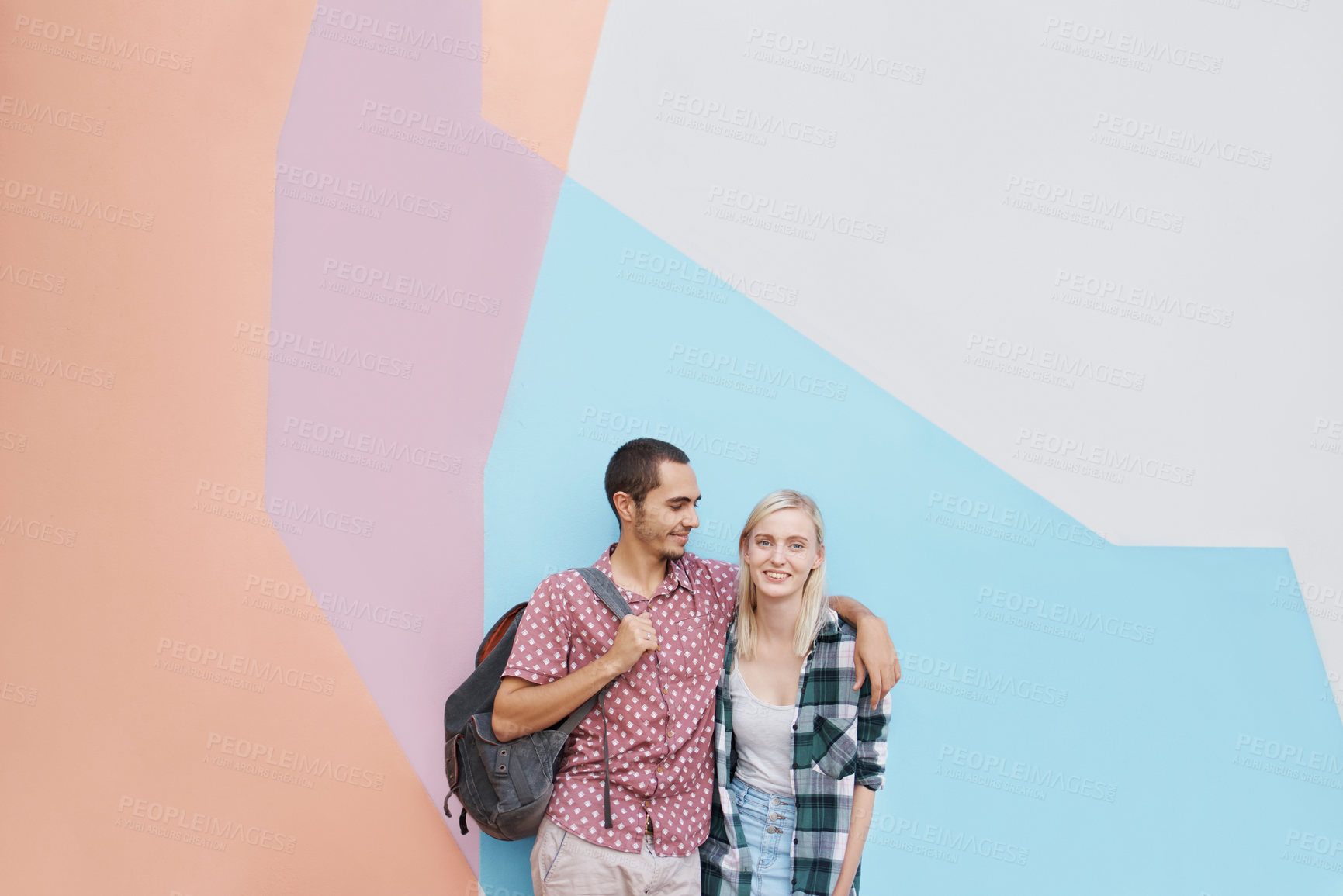 Buy stock photo Couple, students and embrace for love, bonding together and hug on university campus. Color block, happiness and young woman with man on college ground for knowledge, higher education or scholarship