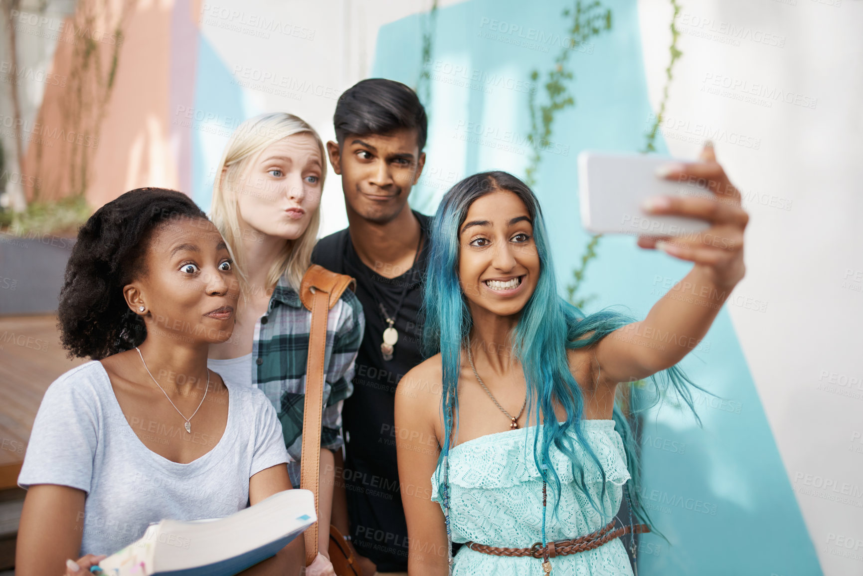 Buy stock photo Shot of a group of young students enjoying a break outdoors on campus