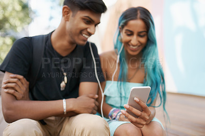 Buy stock photo Couple, earphones and student with mobile phone for funny meme, podcast or watch video on campus. Headphones, Indian man and woman with smartphone for social media, online app or web browsing