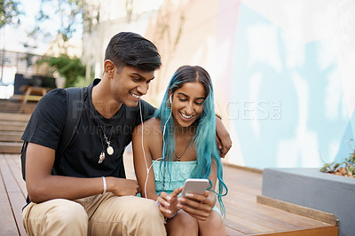 Buy stock photo Couple, earphones and student with smartphone for social media, meme or watching video on campus. Headphones, happy man and woman with mobile phone for internet search, online app or web browsing