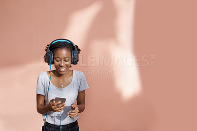 Buy stock photo Girl, headphones and phone for song in studio, website and online for streaming playlist on pink background. Black female person, mockup space and internet for social media, kpop and app for music