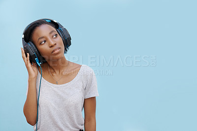 Buy stock photo Thinking, music or headphones by black woman with mockup for sound, track or listening to podcast on blue background. Streaming, announcement or gen z student with radio, playlist or audio ebook