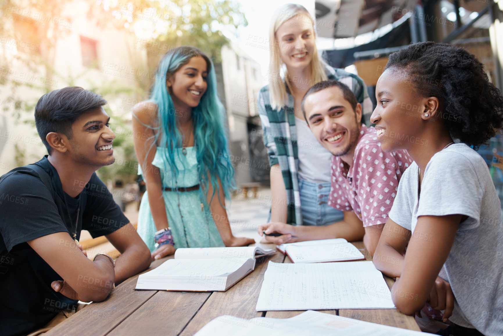 Buy stock photo Shot of a group of young students enjoying a break outdoors on campus