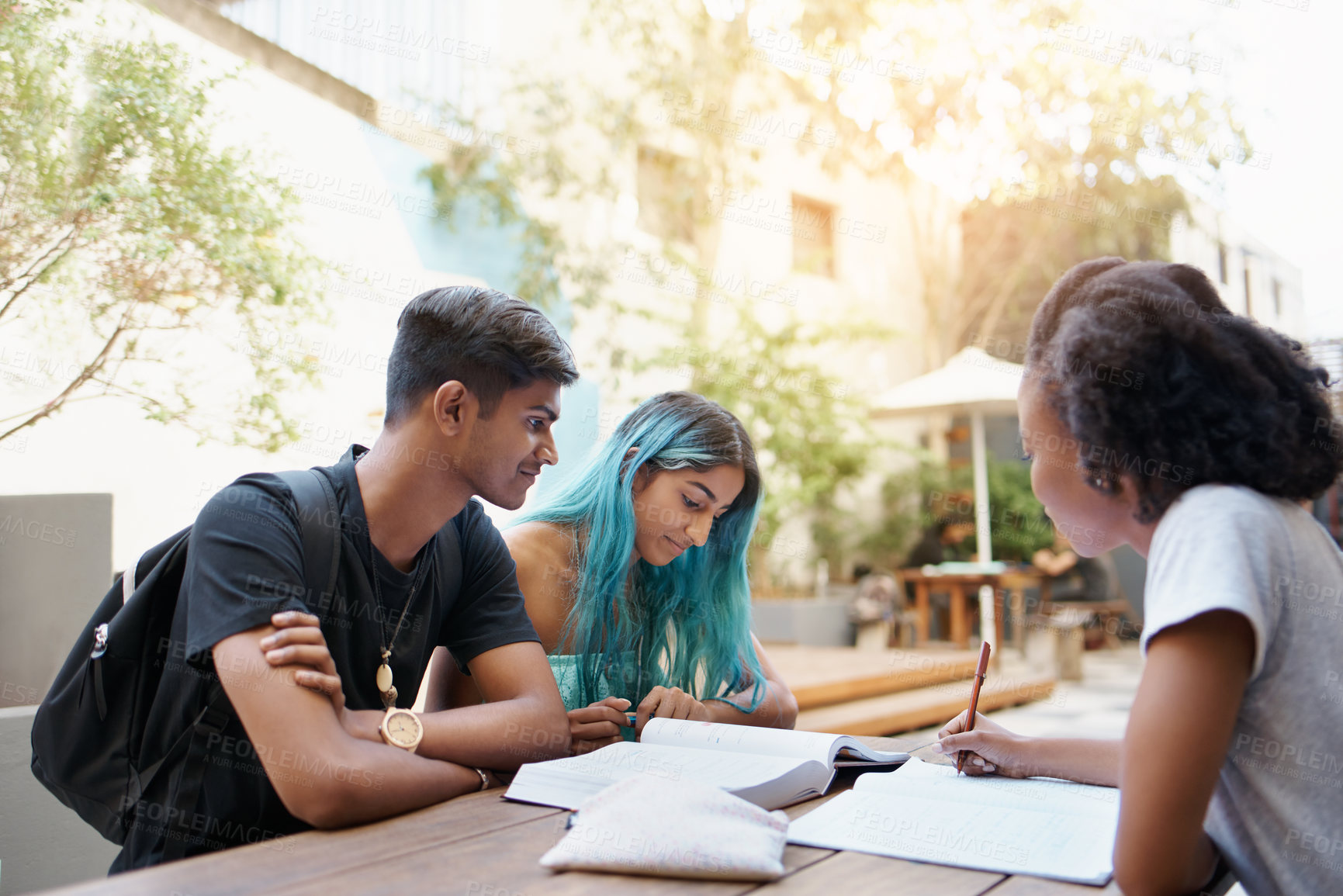 Buy stock photo Students, writing and study outdoor at university with books, reading and learning for education on campus. Friends, gen z people and group research with smile, diversity and college break by table