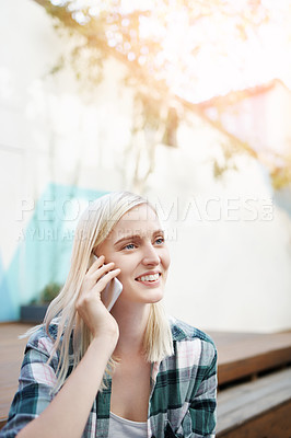 Buy stock photo Shot of a young woman sitting on the steps outside and using a mobile phone