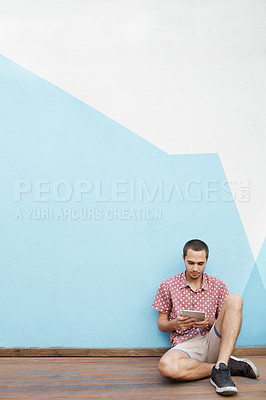 Buy stock photo Male student, sitting on floor and tablet for online streaming, mobile learning or virtual entertainment. Young man, relax and digital tech for internet and social media on break with mockup space  