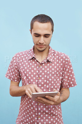Buy stock photo Male student, standing and tablet for video streaming, mobile learning or virtual entertainment outdoor. Young guy and looking on digital tech for online internet, app and social media on break 